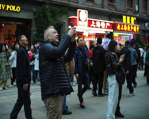 person checking smartwatch in a busy street